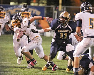 Mcdonald's Matt Morrell (6) breaks a tackle by Lowellville's Eric Grow (11) during the first quarter of Friday nights matchup at Lowellville High School.  Dustin Livesay  |  The Vindicator  10/18/13  Lowellville High School.