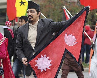 Youngstown State senior Arbin Shrestha carries the Nepal flag while walking with the international students during the Homecoming parade on Fifth Ave. in Youngstown on Saturday. Dustin Livesay  |  The Vindicator 10/19/13  Youngstown.