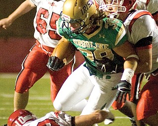 Ursuline wide receiver Vito Penza fights to avoid the tackle Friday night against a pack of Steubenville 
defenders at Stambaugh Stadium in Youngstown. After logging more than 1,000 miles on its first four road trips, the Irish are happy to be “away” for Friday’s game against Cardinal Mooney.