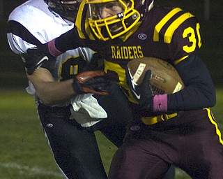 Kelli Cardinal/The Vindicator .South Range (#30) carries the ball Friday night and tries to avoid the tackle by Springfield (#86) at Memorial Field in North Lima.