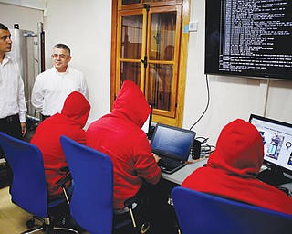 Israel’s Electric Corp. Vice President Yasha Hain, second from left, and Ofir Hason watch a cyber team work at the “CyberGym” school in the city of Hadera. When Israel’s military chief delivered a high-profile speech this month outlining the greatest threats his country will face in the future, he listed computer sabotage as a top
concern, warning a sophisticated cyberattack could one day bring the nation to a standstill.