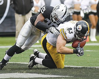 Pittsburgh Steelers tight end Heath Miller tries to control a pass as he is tackled by Oakland Raiders cornerback and Youngstown State football standout Brandian Ross during the fourth quarter of their NFL game Sunday at the O.co Coliseum in Oakland, Calif. The pass was ruled a catch before being overturned as incomplete, and the Raiders hung on to win 21-18.