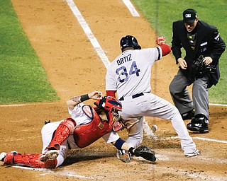 Home plate umpire Paul Emmel watches as Red Sox designated hitter David Ortiz slides safely past Cardinals catcher Yadier Molina on a sacrifice fly by Stephen Drew in the fifth inning of Game 4 of the World Series on Sunday in St. Louis. The Red Sox slipped by the Cardinals to win 4-2 and tie the series at 2-2.