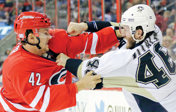 The Hurricanes’ Brett Sutter and Penguins’ Joe Vitale come to blows during the first period of their game Monday in Raleigh, N.C. The Penguins downed the Hurricanes, 3-1.