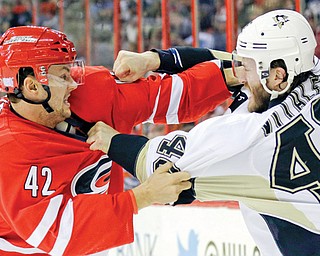The Hurricanes’ Brett Sutter and Penguins’ Joe Vitale come to blows during the first period of their game Monday in Raleigh, N.C. The Penguins downed the Hurricanes, 3-1.