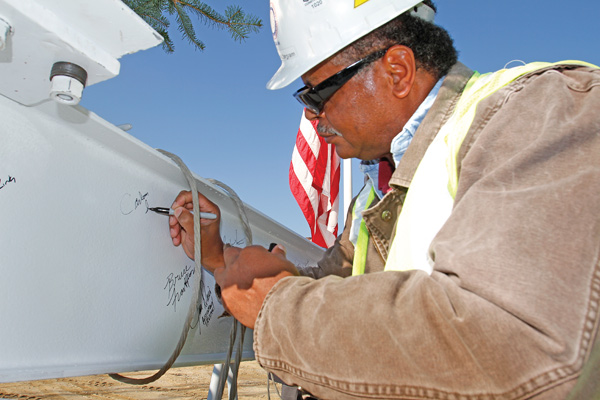 Carlton Ingram, Local 66 operating engineers business manager, signs a steel beam before it was placed on the main building at the Hollywood Gaming at Mahoning Valley Race Course site in Austintown on Tuesday.