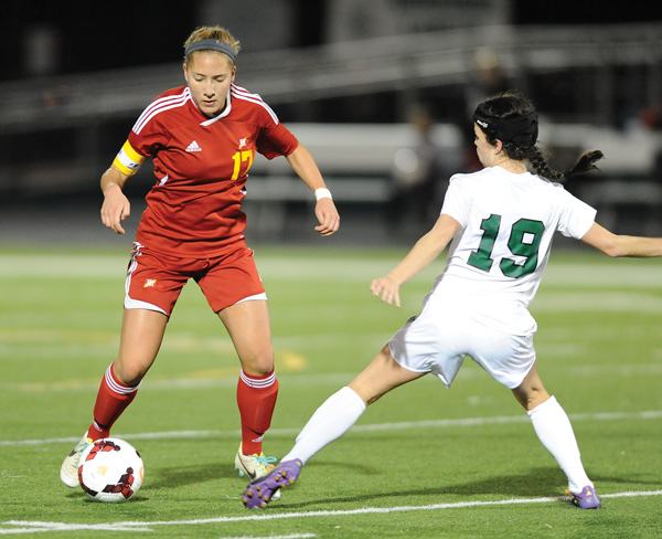 Cardinal Mooney’s Juliana Vazquez (17) dribbles around Elyria Catholic defender Jenna Ellingson (19) on Tuesday night during the second half of a Division III girls soccer regional semifinal.