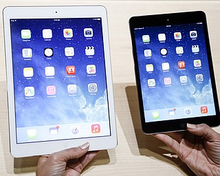 An Apple employee demonstrates the new iPad Air, left, and iPad mini in San Francisco. Analysts say the iPad is facing its stiffest holiday-season competition since its 2010 introduction.