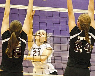 South Range’s Lexi Desantis hits the ball over the net as Triway’s Macie Wengerd (18) and Courtnay Cruise (24) defender during a Division III regional semifinal volleyball match Wednesday at Barberton High School. The Raiders fell 3-1.