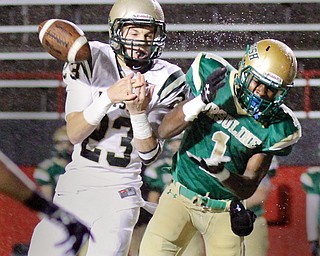 Ursuline’s Ben Phillips (1) and Akron SVSM’s Nathan Bischof (23) battle for a pass during the first quarter of Thursday’s game at Stambaugh Stadium. SVSM won 40-7.