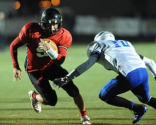Canfield #9 Kimu Kim runs the football through the arm tackle of Hubbard #16 Ethan Wassil on a run during the 1st quarter of Friday nights game.