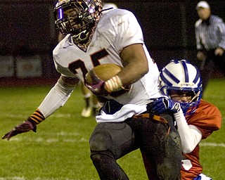 Kelli Cardinal/The Vindicator .Wellsville running back Brendon Carr tries to avoid a tackle Friday night against Western Reserve defender Josh Vuletich on the Blue Devils field in Berlin Center.