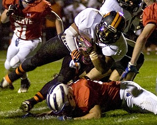 Kelli Cardinal/The Vindicator .Wellsville running back Brendon Carr holds onto the ball Friday night against Western Reserve defenders on the Blue Devils field in Berlin Center.