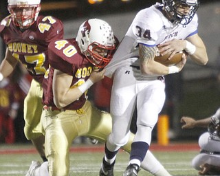 . ROBERT K. YOSAY | THE VINDICATOR..Fitch #34 Sam Ortz gets jerey tackled by mooney #40 Andrew Armstrong and #47 Nick Huber t looks on..Austintown Fitch @ Mooney at Stambaugh Stadium