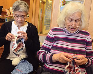 Sue Haek, left, of Boardman and Jeanie Williams, also of Boardman, crochet squares to make afghans that will be donated to area hospitals. The two are part of a group that meets at Fellows Riverside Gardens in Mill Creek Park.