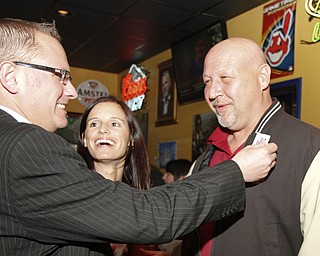 MADELYN P. HASTINGS I THE VINDICATOR..Jim Davis gives Joe Halas an election sticker while Maria Morales-Latone laughs during the election party at Jay Jay's Roadhouse on November 5, 2013.