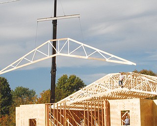 Dale Murphy guides the positioning of trusses on Boardman Baptist Church, where he is working with Martin Eaton through Baptist Church Planters of Grafton, Ohio. The expansion of the church on Shields Road includes new sanctuary, offi ces and choir room. Construction began in June, and projected completion is September 2014.
