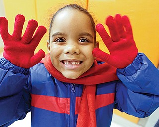 Diamonique Washington, a Harding Elementary School student, shows off the new coat, gloves and scarf she got from the Rotary Club of Youngstown. The club raised nearly $18,000 to buy coats and scarves for all the students at the Youngstown school. Youngstown State University’s Rotaract Club raised money to buy the gloves.