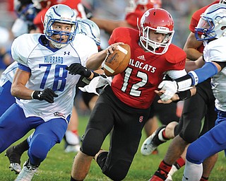 Struthers quarterback Gary Muntean tries to get by Hubbard defenders Jake Frost (78) and Cole Benectic (6) during their regular-season game in Struthers. The Wildcats narrowly missed the postseason last year and
were bound and determined not to let that happen again this season. And, their hard work paid off: Struthers
will host Lakeview on Friday in Week 1 of the 2013 playoffs.