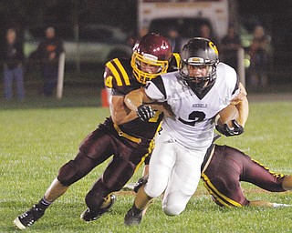 Crestview’s Trevor Cope (2) is wrapped up by South Range defender Bryce Allen during a regular-season game at South Range Stadium. Both teams have advanced to postseason play. The Raiders will host Cuyahoga Heights on Friday, while the Rebels are prepping for a rematch against Liberty on Saturday.