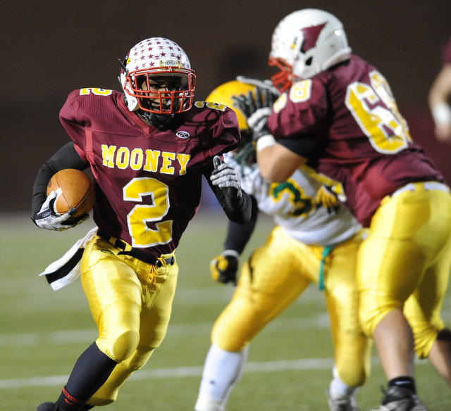 Mooney #2 C.J. Amill runs the football behind the block of offensive linemen #68 Zach Dundics on John Hay #3 Latif Hughes during the 3rd quarter of Friday nights game.