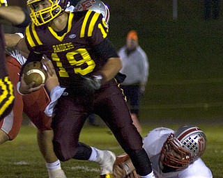 Kelli Cardinal/The Vindicator .South Range quarterback Ryan Miller carries the ball and avoids the tackle by a Cuyahoga Heights defender during the first half Friday night at Memorial Field in North Lima.