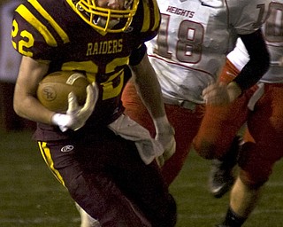 Kelli Cardinal/The Vindicator .South Range running back Billy Goodall carries the ball past Cuyahoga Heights defender Chandler Holesovsky during the first half Friday night at Memorial Field in North Lima.