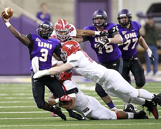 Northern Iowa quarterback Brion Carnes just gets a pass away before being tackled by Youngstown State defenders in the second half of the game at the UNI-Dome in Cedar Falls, Iowa, Saturday, Nov. 9, 2013.