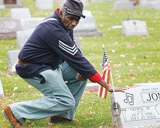 Steffon Jones, a local historian, places his hand on his father’s headstone. George W. Jones Jr., known for his singing talent, served three years in the Air Force during the 1950s.