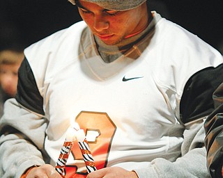 Sharon football player Troy Hejazi mourns teammates Corey Swartz and Evan Gill during a vigil Sunday at the
stadium.