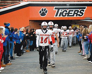 Supported by a group of family and friends, the Sharon High football team walks out onto the field Sunday for their first practice since Friday’s auto accident that claimed the lives of two teammates and left two more hospitalized. The tragedy came a day before the Tigers were to face Girard (Pa.) in Round 1 of the PIAA playoffs,
which will be played tonight in Erie. Players will wear stickers with “C.S.” and “E.G.” on their helmets to honor teammates Corey Swartz and Evan Gill, who were killed.