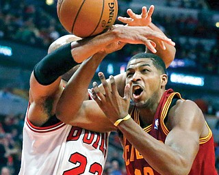 Bulls forward Taj Gibson (22) fouls Cavaliers forward Tristan Thompson during the first half of Monday’s game in Chicago. The Cavs lost, 96-81.