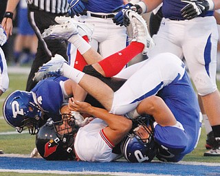 Canfield’s Kimu Kim (9) is stopped by Poland’s Dylan Garver (4) and Dom Petrony (2) during their Week 5 game in Poland. Because of an injury, Petrony is now the Bulldogs quarterback.