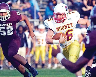 Cardinal Mooney quarterback Jon Saadey takes off running with the football as he’s chased by Boardman defender Alex Birchfield during a regular-season game. The junior quarterback has been tasked with running the Cardinals’ run-first offense that is preparing for a second-round playoff game against Struthers.
