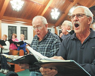Robert Greitzer of Braceville, left, and John Viggiano of Poland give it their all during a recent rehearsal of Mahoning Valley Chorale at Good Hope Lutheran Church in Boardman. The group, formerly known as Seraphim Chorus, changed its name to better reflect its music and members.