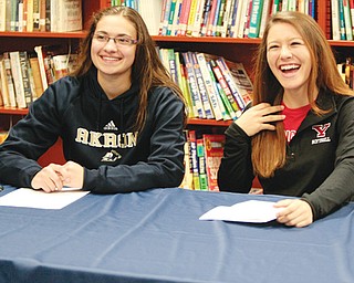 Austintown’s Megan Sefcik and Cali Mikovich sign their letters-of-intent Wednesday at the Fitch High School Library. Sefcik will play basketball at Akron, and Mikovich will play softball at Youngstown State.