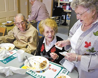 Kelli Cardinal/The Vindicator .Betty Clayton, right, from Salem, hands out a poem called "Pennies from Heaven" to Marilyn Burkley, from Canfield, and her husband, Sam, during the Salem Scampers annual fish and chicken fry Sunday in North Jackson. The Burkleys joined the Scampers in 1980.