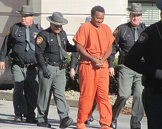 Trumbull County deputy sheriffs surround TaShawn Walker as he is brought from the county jail to the courthouse Thursday for his arraignment on an aggravated murder charge.