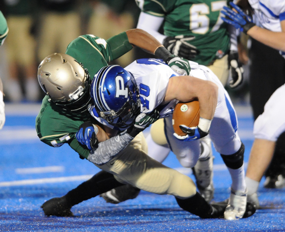 Poland #20 Ross Gould is tackled and dragged down to the ground by St. Vincent - St. Mary #47 Dante Booker during Friday nights game in Ravenna.