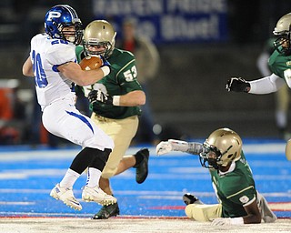 Poland #20 Ross Gould spins away from would be St. Vincent - St. Mary tacklers #53 Anthony Adkins and #9 Tyrece Speaight during Friday nights game in Ravenna.
