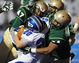 Poland #20 Ross Gould is wrapped up by St. Vincent - St. Mary tacklers #34 Newman Williams and #47 Dante during Friday nights game in Ravenna.