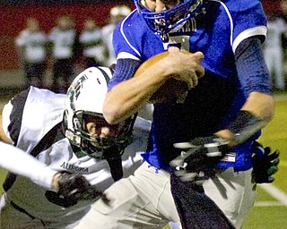 Kelli Cardinal/The Vindicator .Hubbard quarterback Brennan Wassil attempts to avoid the tackle Friday night by Aurora defender Ryan Devine at Falcon Field in Austintown.