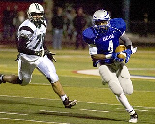 Kelli Cardinal/The Vindicator .Hubbard running back George Hill carries the ball Friday night past Aurora defender Mitch Deininger at Falcon Field in Austintown.