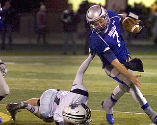 Kelli Cardinal/The Vindicator .Hubbard quarterback Brennan Wassil attempts to avoid the tackle Friday night by Aurora defender Kirk Janoch at Falcon Field in Austintown.