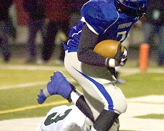 Kelli Cardinal/The Vindicator .Hubbard running back Larry Scott carries the ball into the end zone Friday night past Aurora defender Ryan Devine at Falcon Field in Austintown.
