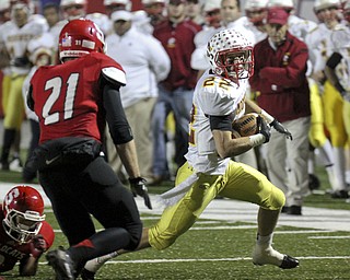 William D Lewis The Vindicator y Mooney's Mark Handel(22) eludes Struthers Nick Pollifrone(21)during playoff action Friday in Niles.