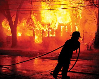 Youngstown firefighters attempt to put out a massive fire at a vacant house located off Market Street in Youngstown.