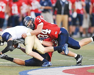 Fitch defenders Sam Ortz (34) and Ryan Sayers drag down Hoban’s Jake Tersigni on a sweep play during a regular-season game at Falcon Stadium in Austintown. For the third time in 28 seasons, the Falcons are practicing for a Week 13 game. They take on Lakewood St. Edward on Friday in the Division I state quarterfinal in Akron.
