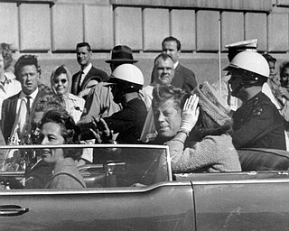 President John F. Kennedy is seen riding in motorcade approximately one minute before he was shot in Dallas, Tx., on Nov. 22, 1963.  In the car riding with Kennedy are Mrs. Jacqueline Kennedy, right, Nellie Connally, left, and her husband, Gov. John Connally of Texas. 