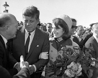 President John F. Kennedy and first lady Jacqueline Kennedy on their arrival at the Dallas Airport (Love Field) on Nov. 22, 1963. They are greeting unidentified people. (AP Photo/HWB)